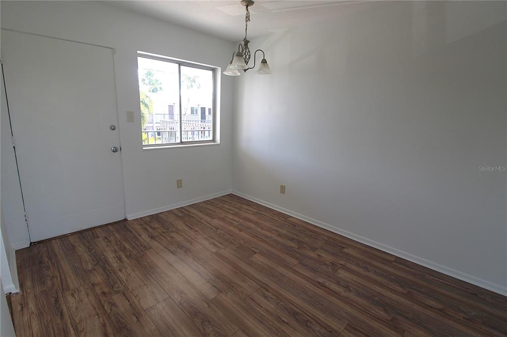 3101 Bee Ridge Road, Unit 215 Sarasota, FL 34239 - Photo 5 of 15 wooden floor in an empty room with a window