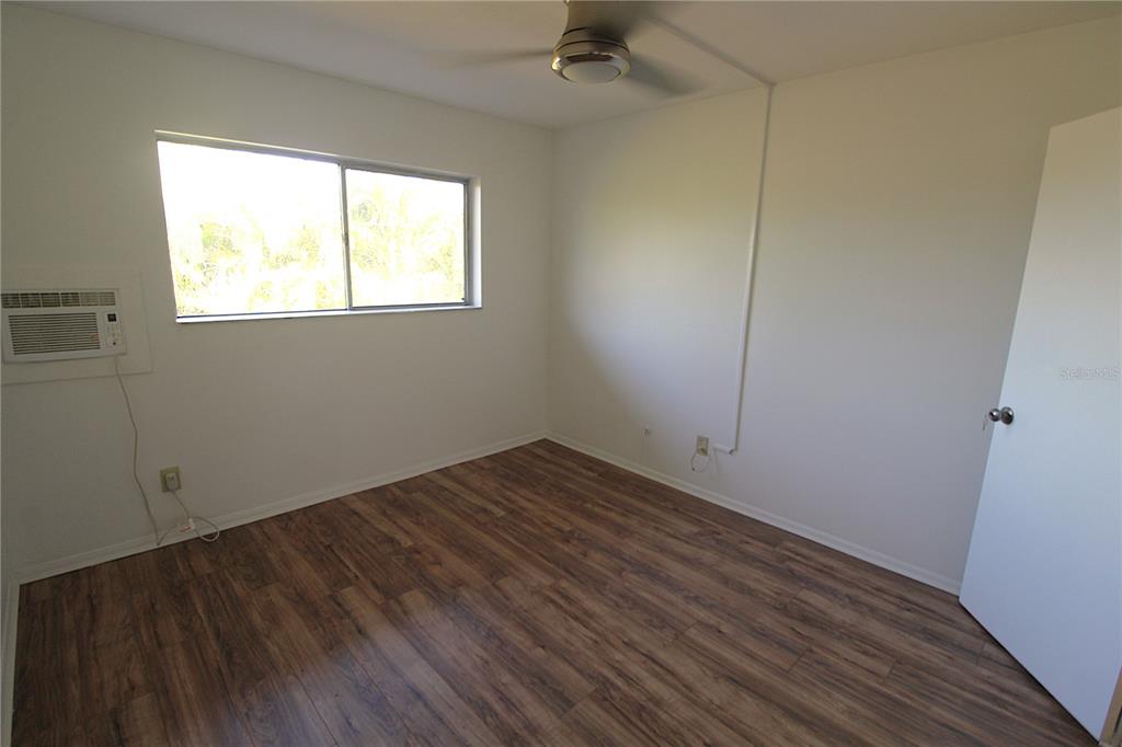 3101 Bee Ridge Road, Unit 215 Sarasota, FL 34239 - Photo 9 of 15 a view of an empty room with wooden floor and a window