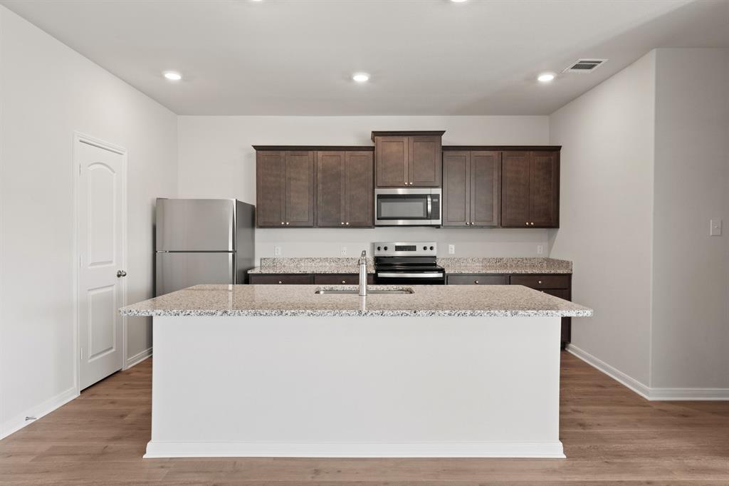 137 Magnolia Boulevard Hutchins, TX 75141 - Photo 2 of 8 a kitchen with stainless steel appliances granite countertop a sink a microwave a refrigerator and a stove