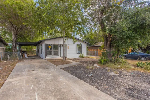 a view of a house with backyard and trees