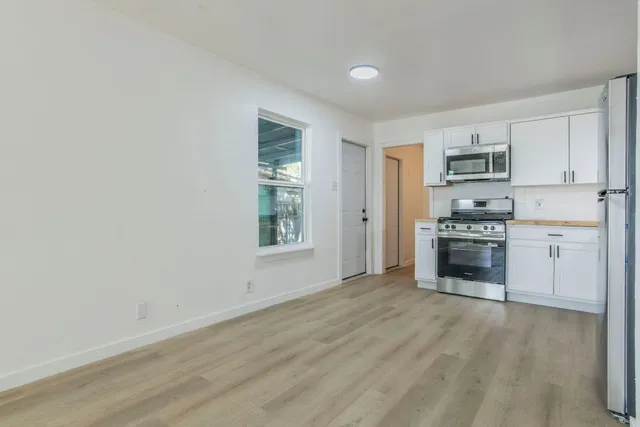 a kitchen with granite countertop a stove a sink and a refrigerator