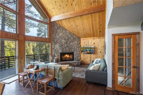 a living room with furniture a fireplace and a floor to ceiling window