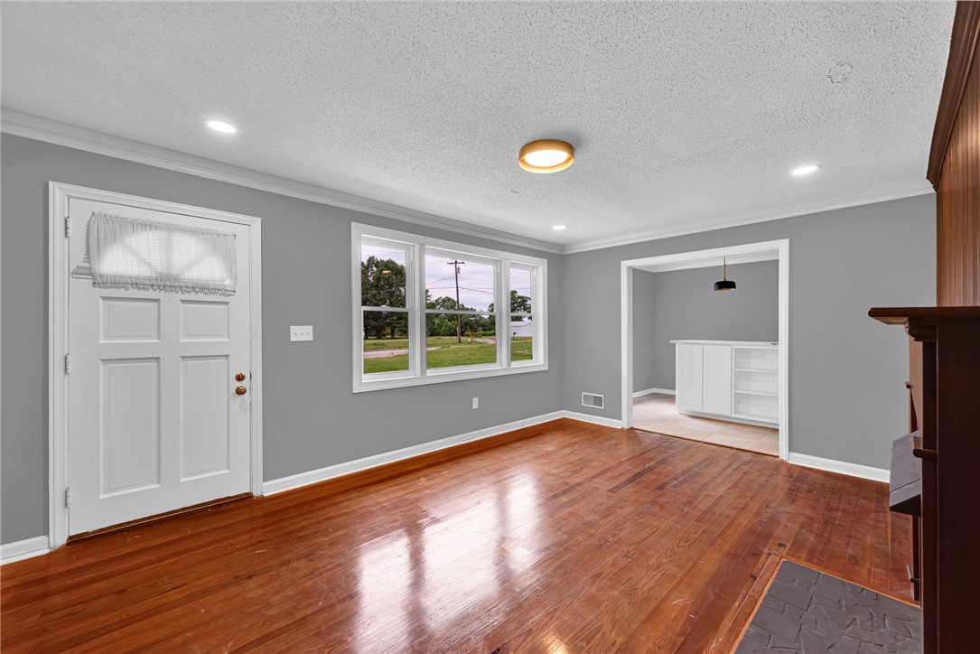 1010 Log Shoals Road Mauldin, SC 29662 - Photo 6 of 28 Hardwood flooring extends throughout this versatile living area, complemented by clean walls and abundant natural light.