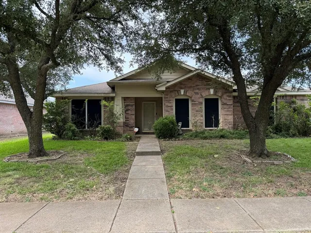 a front view of a house with yard and green space