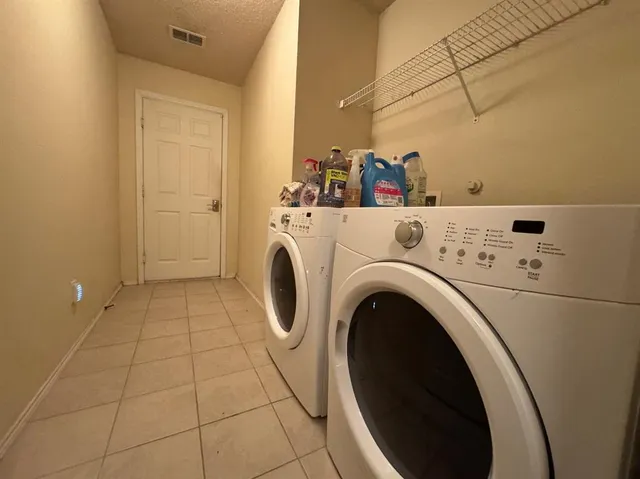 a view of washer and dryer with kitchen in the background