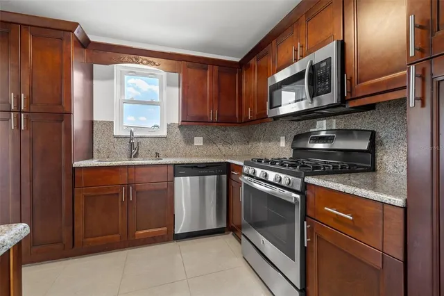 a kitchen with stainless steel appliances granite countertop a sink stove and microwave