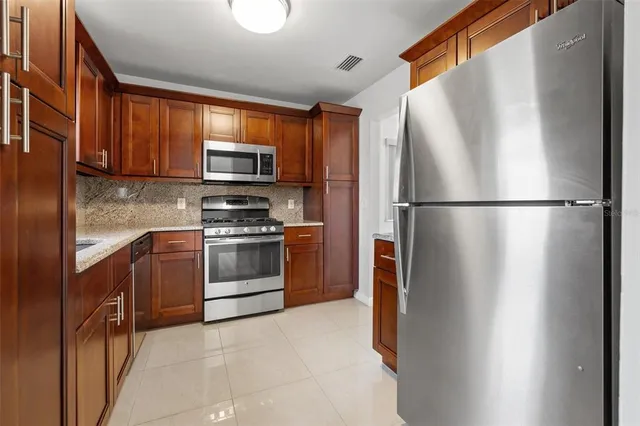 a kitchen with stainless steel appliances a refrigerator sink and microwave