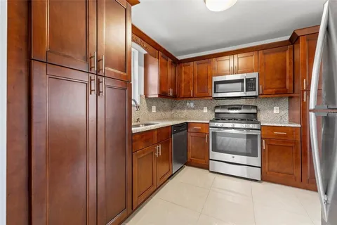 a kitchen with stainless steel appliances granite countertop a refrigerator microwave and sink