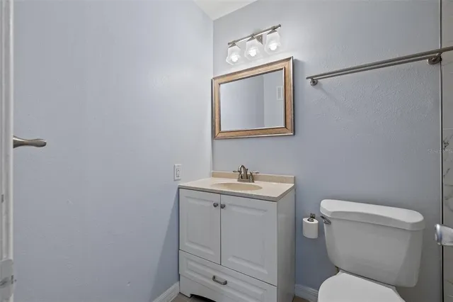 a bathroom with a toilet a sink and mirror