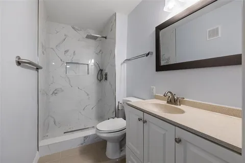 a bathroom with a sink a toilet and shower