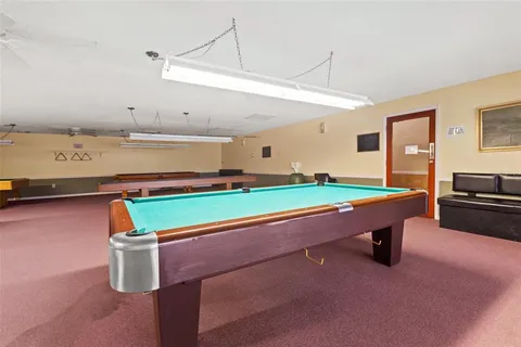 a room with pool table and windows
