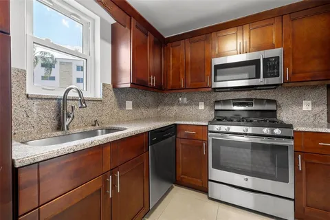 a kitchen with stainless steel appliances granite countertop a sink stove and microwave