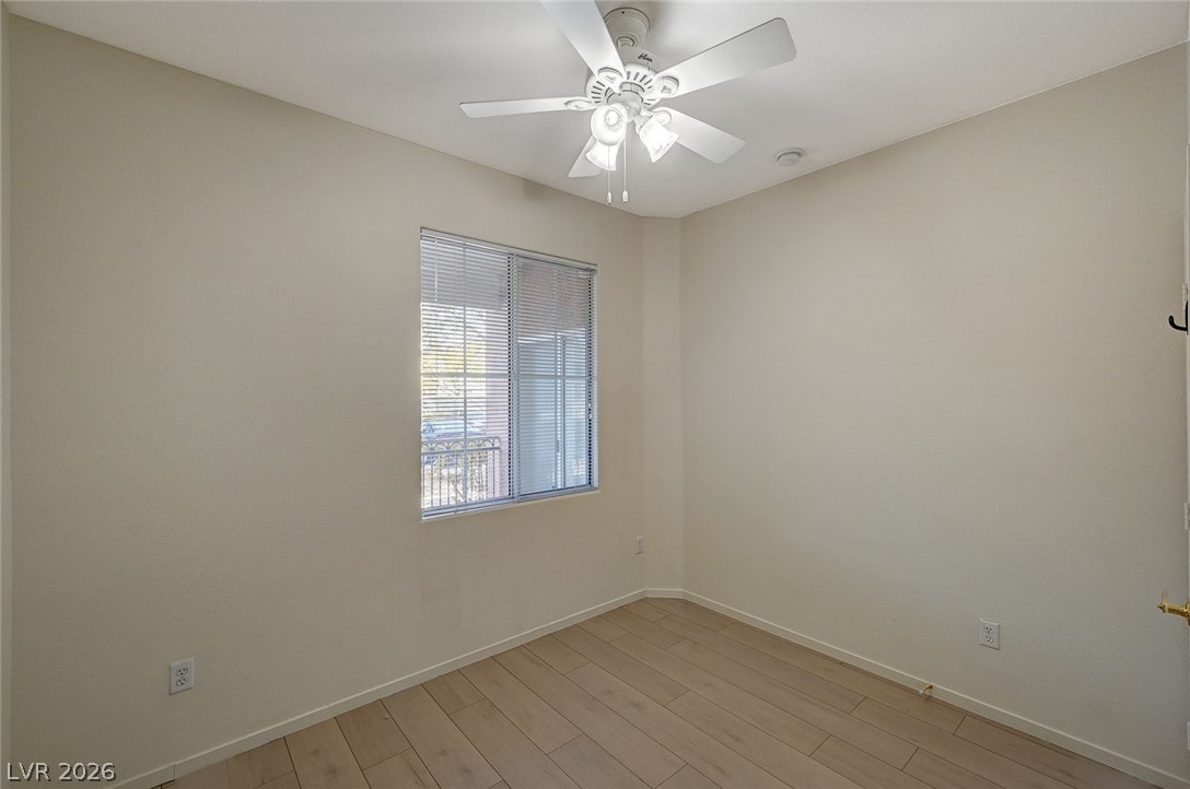 9050 West Warm Springs Road, Unit 1147 Las Vegas, NV 89148 - Photo 31 of 36 A well-lit bedroom features hardwood flooring and a functional ceiling fan for optimal comfort.