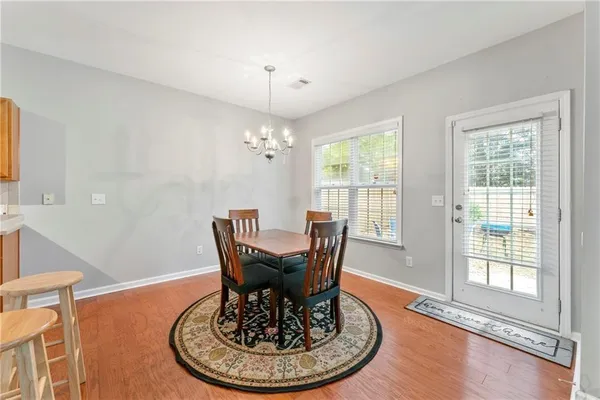 a dining room with furniture a chandelier and wooden floor