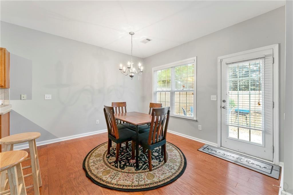 3218 Saville Street Southwest Atlanta, GA 30331 - Photo 4 of 12 a dining room with furniture a chandelier and wooden floor