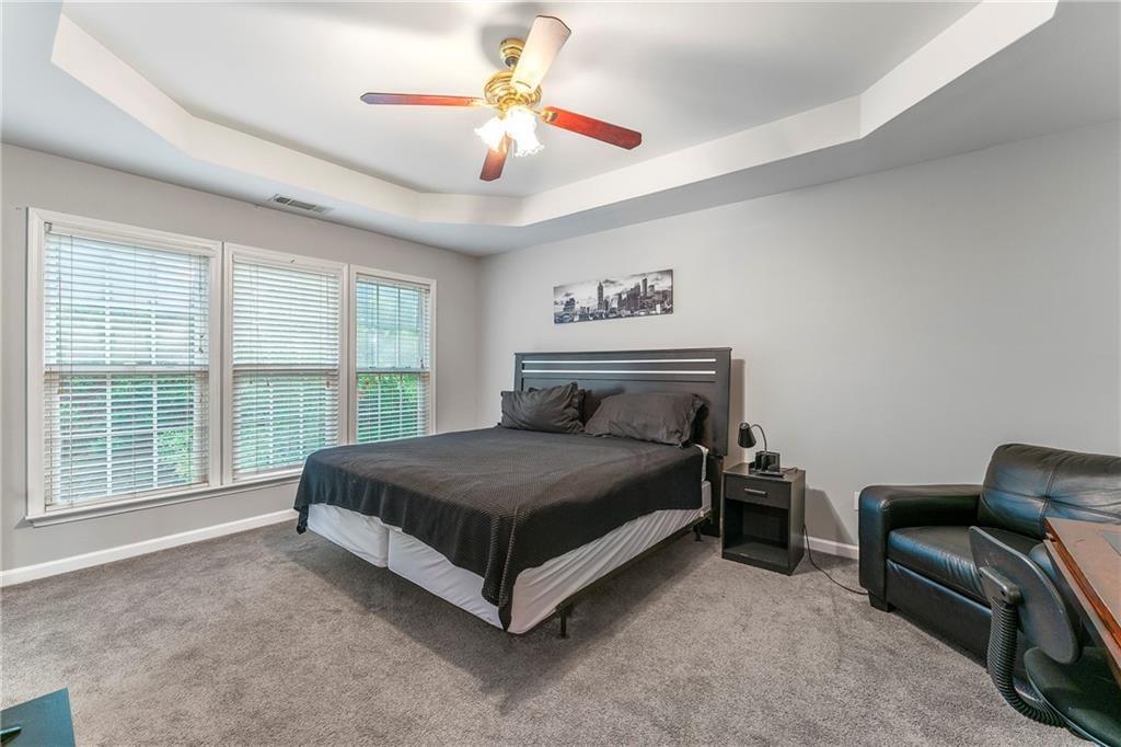 3218 Saville Street Southwest Atlanta, GA 30331 - Photo 8 of 12 a spacious bedroom with a bed a chair and a large window