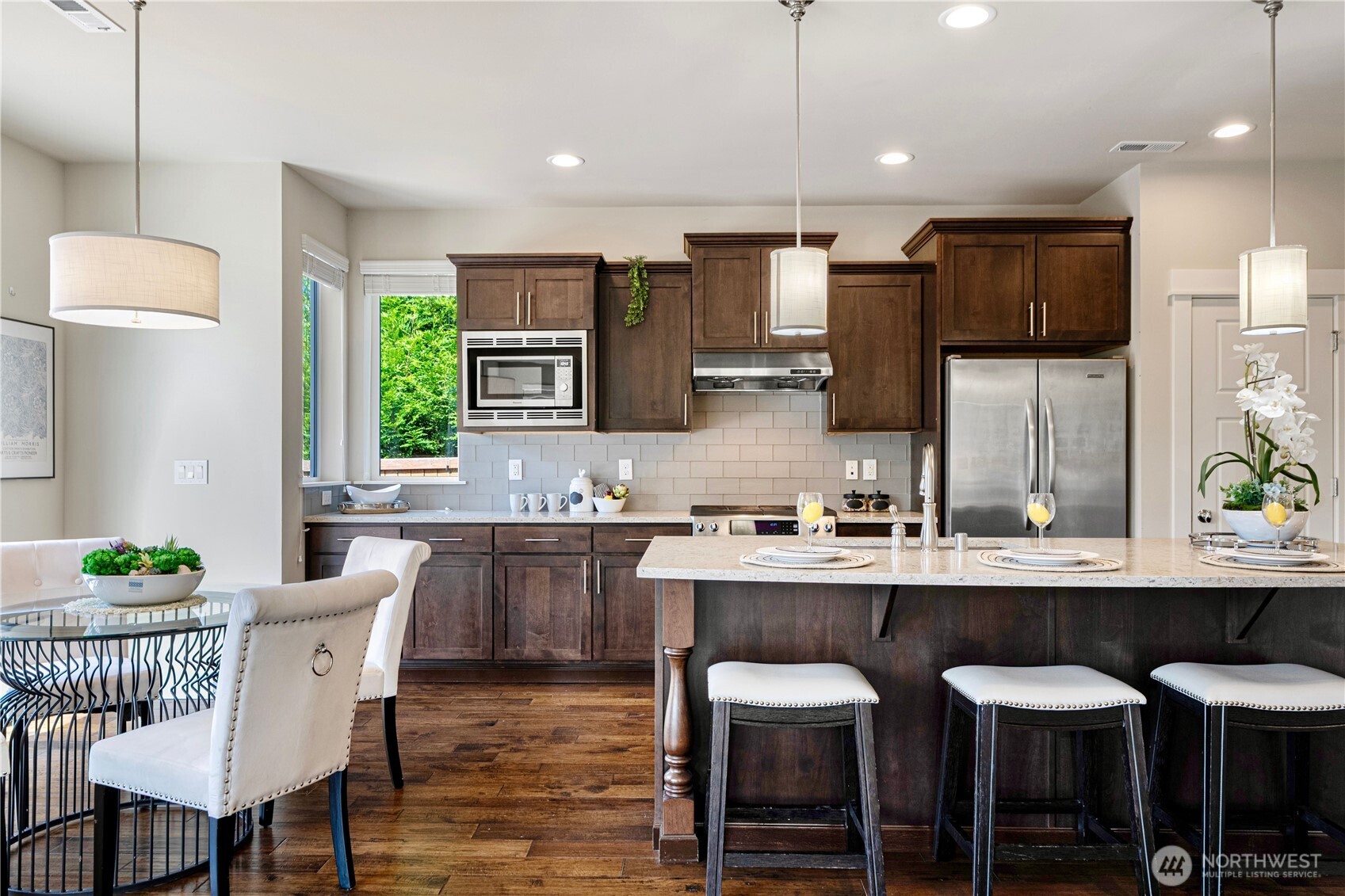 3718 226th Place Southeast Bothell, WA 98021 - Photo 7 of 30 a kitchen with stainless steel appliances a dining table chairs refrigerator and sink