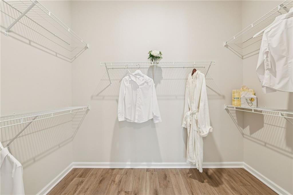 526 Pearl Street Cumming, GA 30040 - Photo 23 of 39 a view of walk in closet with clothes and shoes