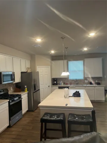a kitchen with a stove a sink a refrigerator and cabinets