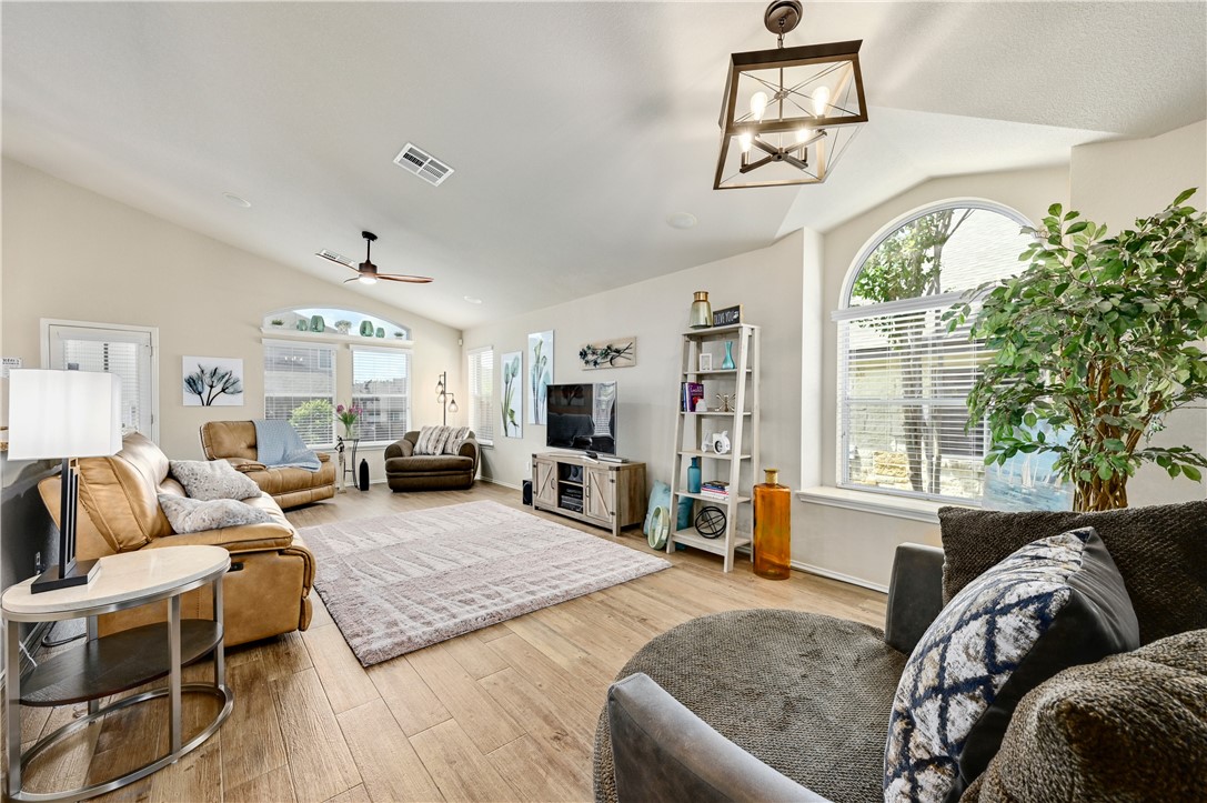 a living room with furniture large window and wooden floor