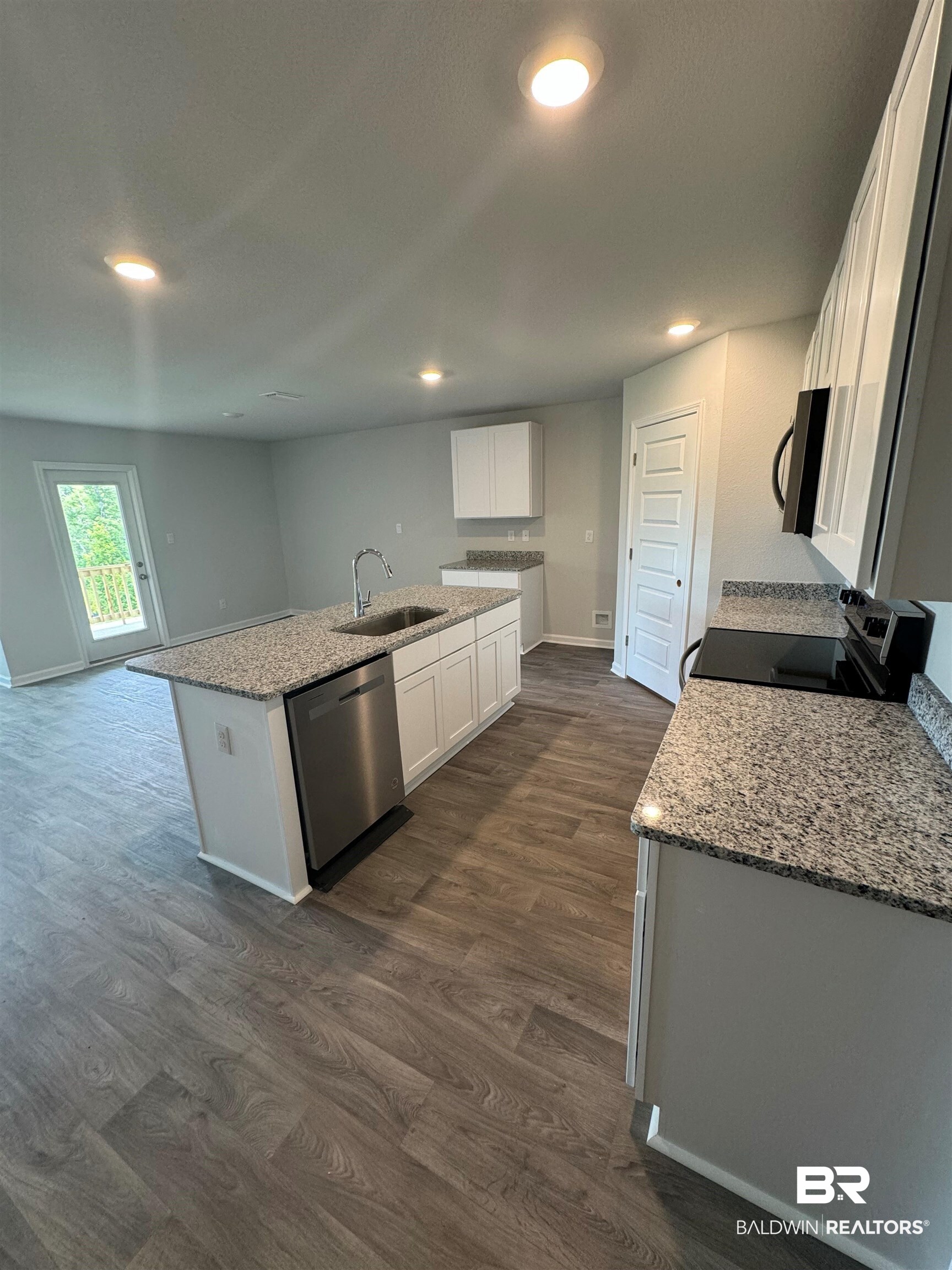 11335 Elemis Drive Daphne, AL 36526 - Photo 8 of 11 Kitchen featuring dark hardwood / wood-style flooring, white cabinets, light stone countertops, stainless steel appliances, and sink