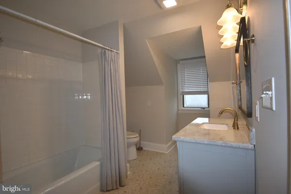a bathroom with a toilet a sink a vanity and mirror