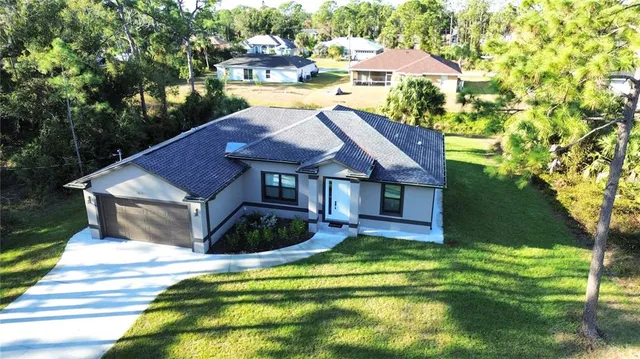 a view of house with garden and swimming pool