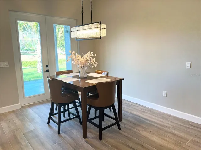 a dining room with furniture a chandelier and wooden floor