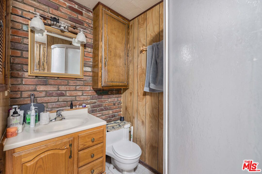 64050 Gallatin Road Gallatin Gateway, MT 59730 - Photo 16 of 55 a bathroom with a granite countertop sink toilet and shower