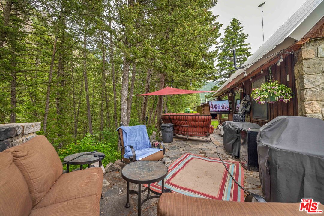 64050 Gallatin Road Gallatin Gateway, MT 59730 - Photo 20 of 55 a backyard of a house with wooden floor and outdoor seating