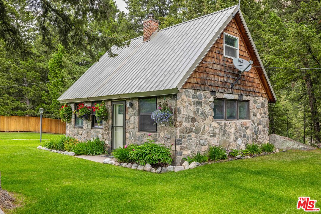 64050 Gallatin Road Gallatin Gateway, MT 59730 - Photo 23 of 55 a front view of house with a garden and plants