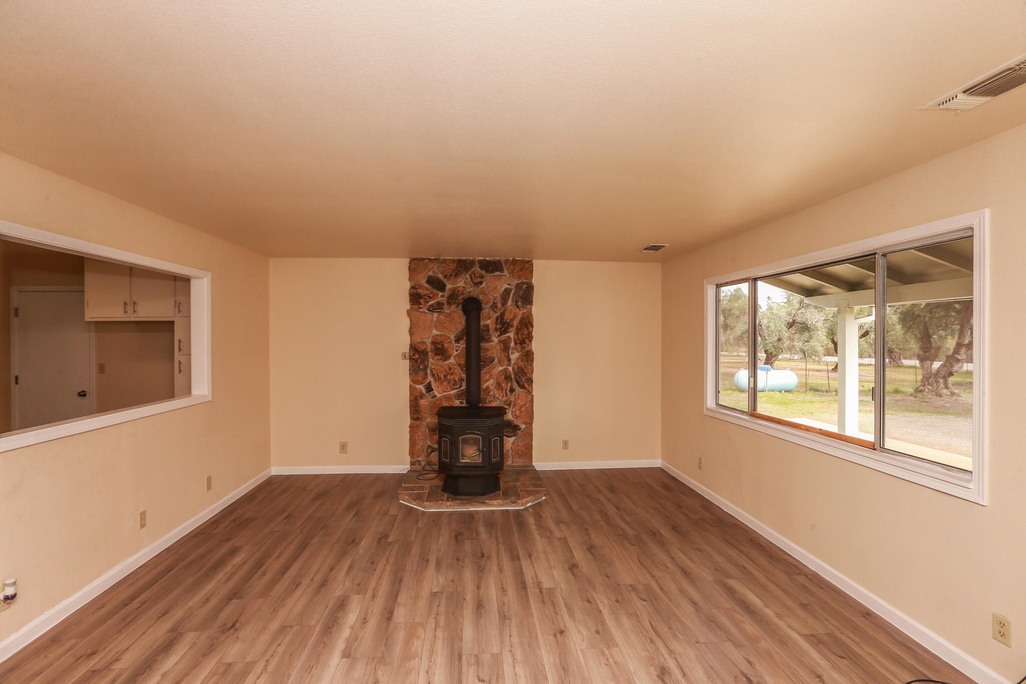 5572 Olive Street Anderson, CA 96007 - Photo 5 of 31 an empty room with wooden floor and windows