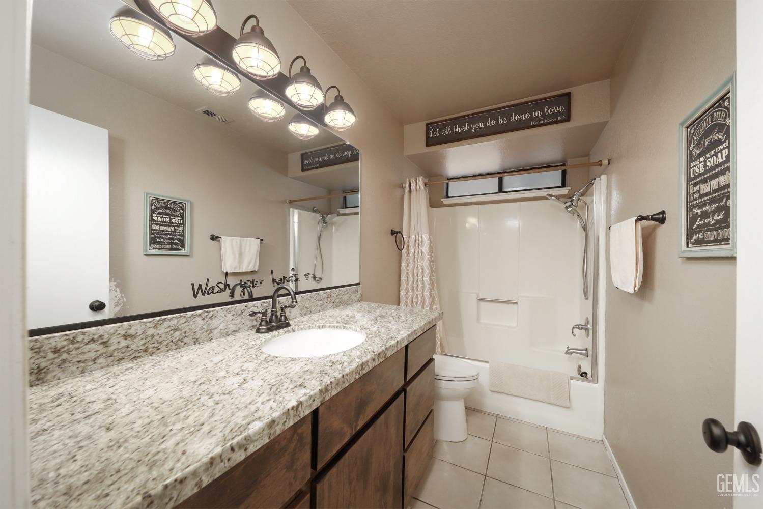 Undisclosed Address Bakersfield, CA 93314 - Photo 16 of 29 a bathroom with a granite countertop sink a toilet and shower