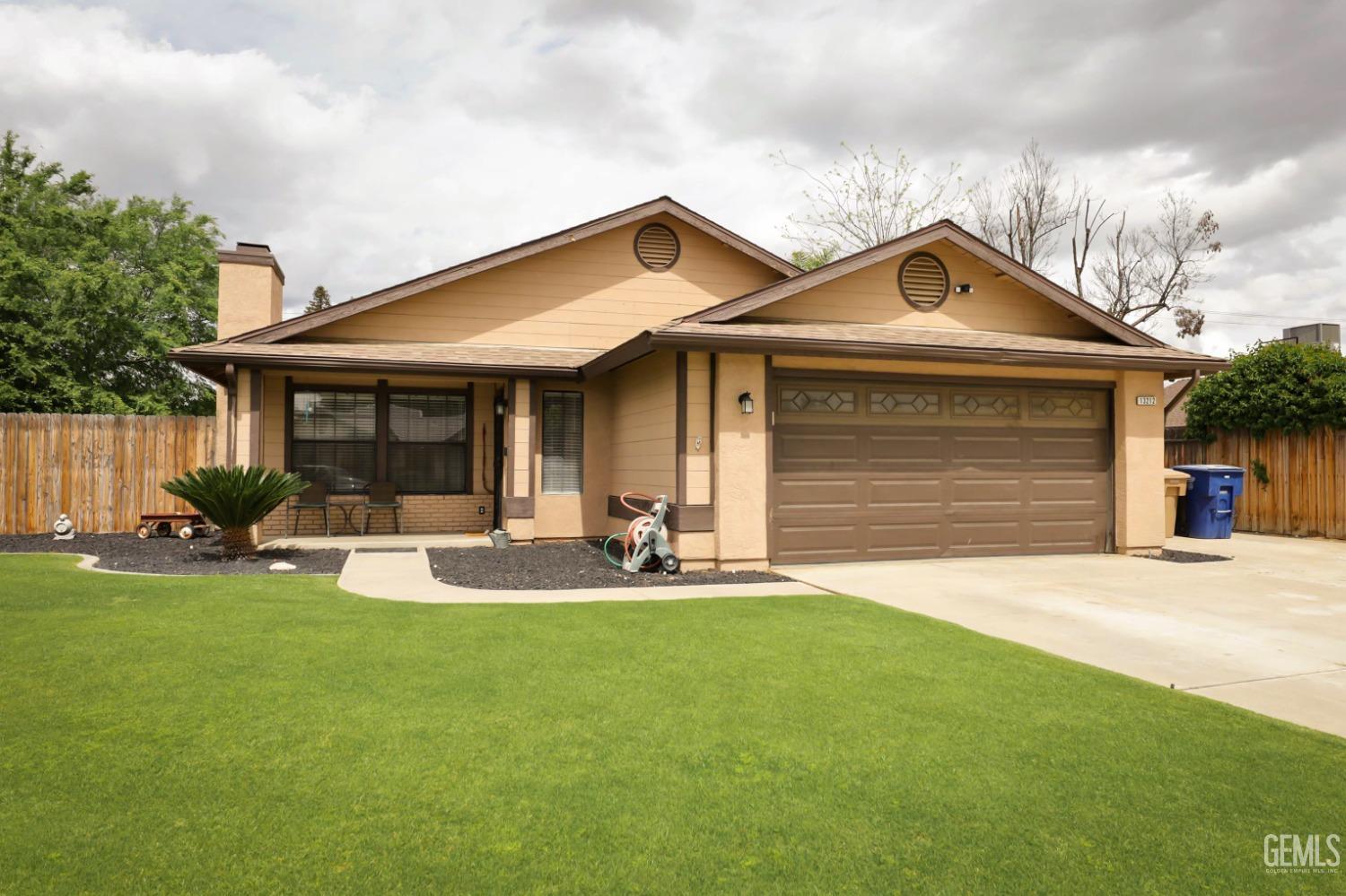 Undisclosed Address Bakersfield, CA 93314 - Photo 6 of 29 a front view of a house with a yard and garage