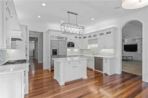 a kitchen with kitchen island white cabinets and stainless steel appliances