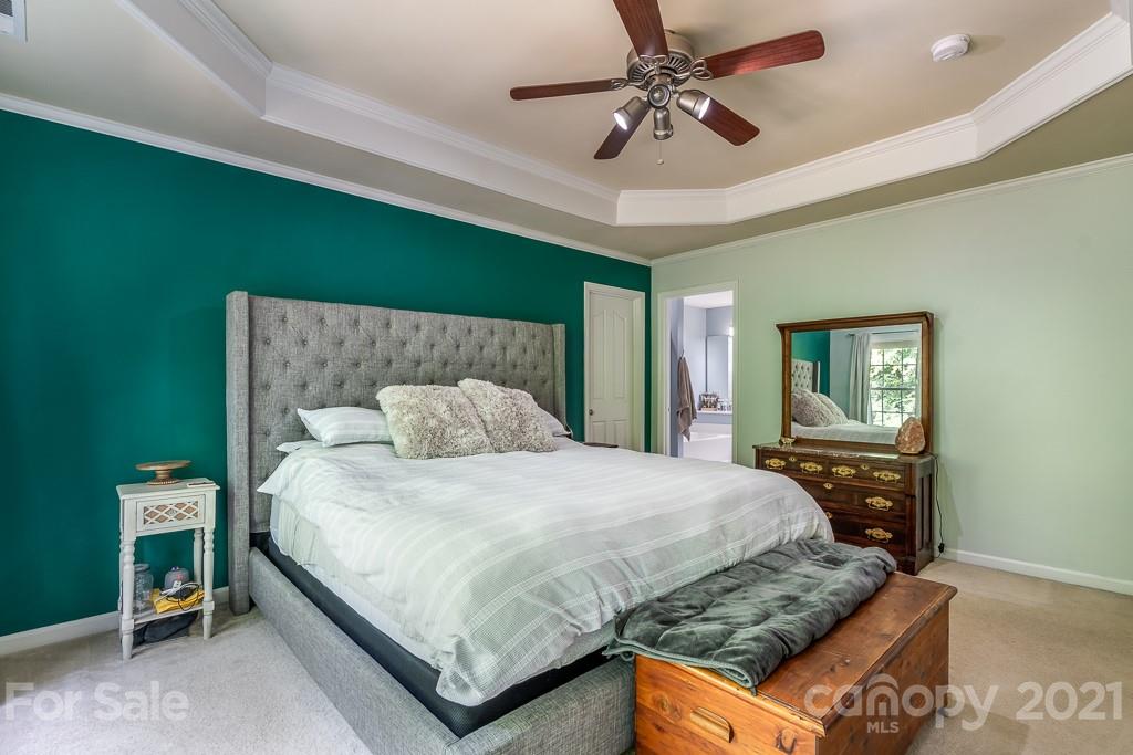 18122 Bluff Inlet Road Cornelius, NC 28031 - Photo 21 of 34 a bedroom with a bed chandelier and a window