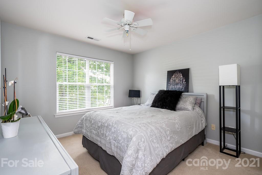 18122 Bluff Inlet Road Cornelius, NC 28031 - Photo 27 of 34 a bedroom with a large bed and a chandelier