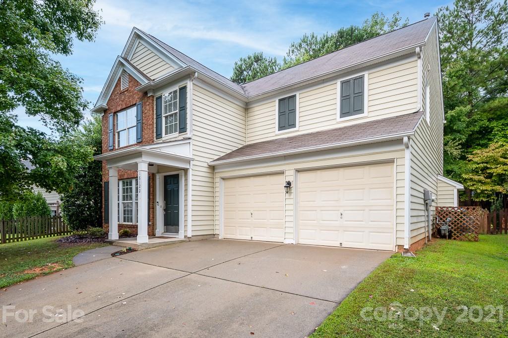 18122 Bluff Inlet Road Cornelius, NC 28031 - Photo 4 of 34 a view of a white house with a large space and a large tree