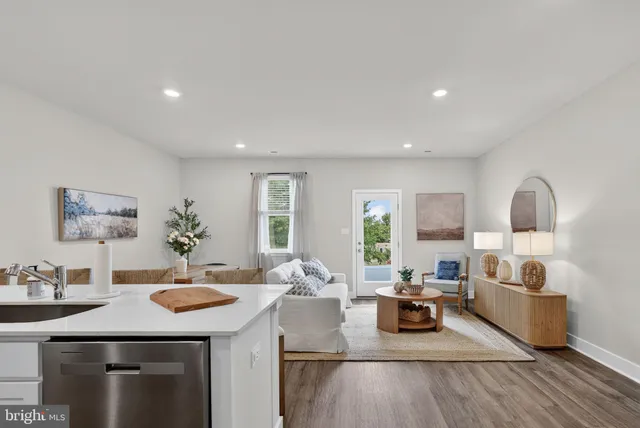 a kitchen with stainless steel appliances kitchen island granite countertop a dining table chairs sink and cabinets