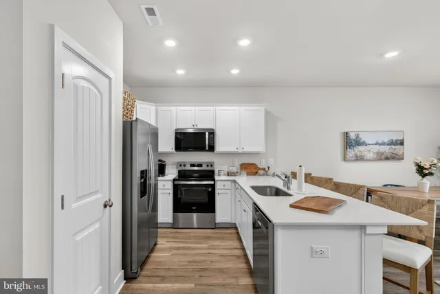 a kitchen with a refrigerator stove and white cabinets