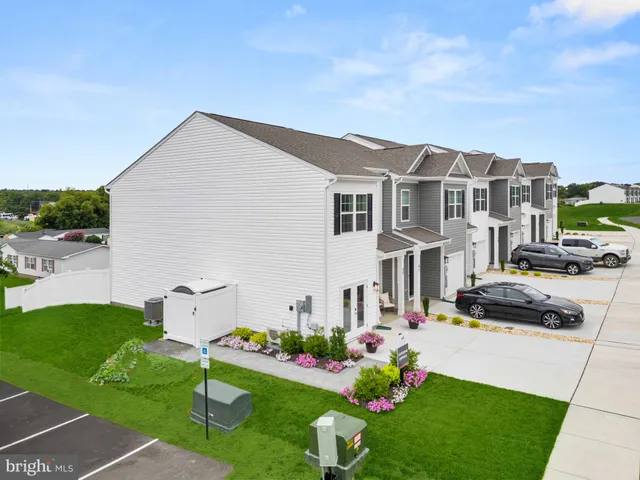 a view of a big house with a big yard and large trees