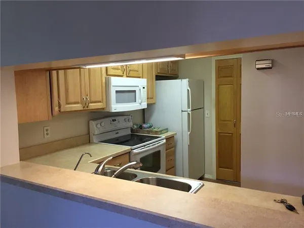 a kitchen with a refrigerator sink and cabinets