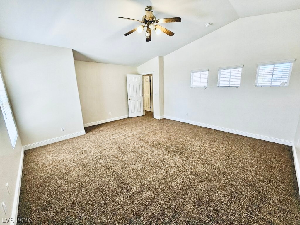 5953 Crumbling Ridge Street Henderson, NV 89011 - Photo 17 of 42 A spacious bedroom offers comfort and a tranquil retreat, featuring plush carpeting and a cooling ceiling fan.
