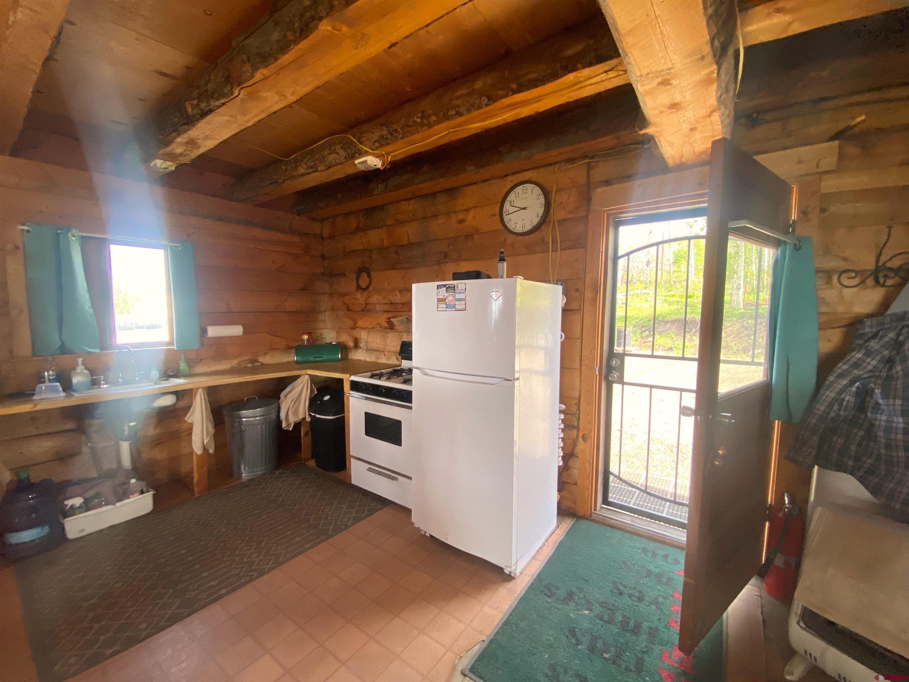 19514 Johnson Road Hotchkiss, CO 81419 - Photo 7 of 27 a kitchen with a refrigerator and wooden floor