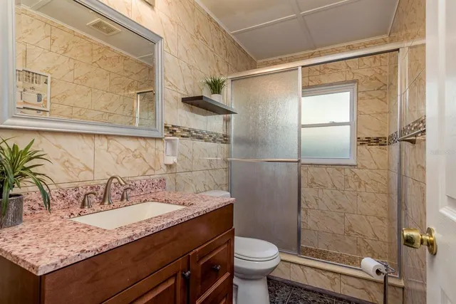 a bathroom with a granite countertop sink toilet and shower