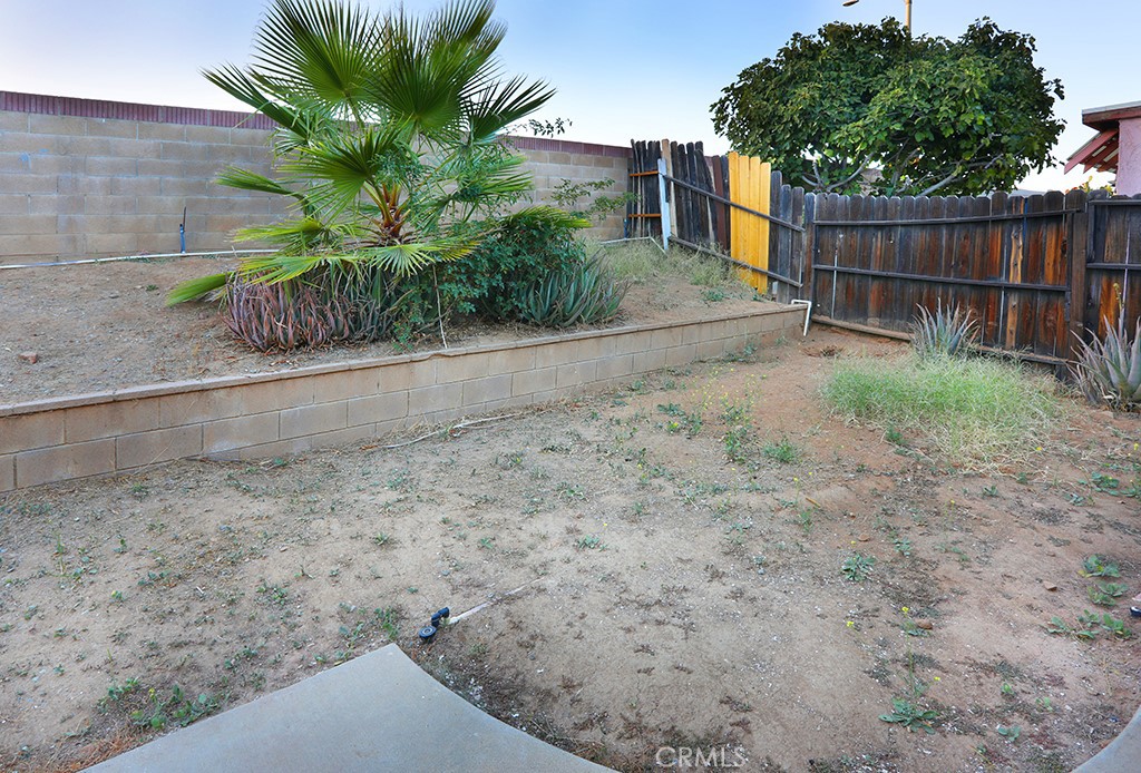 27603 Genevieve Drive Menifee, CA 92586 - Photo 11 of 11 a backyard of a house with potted plants and wooden fence