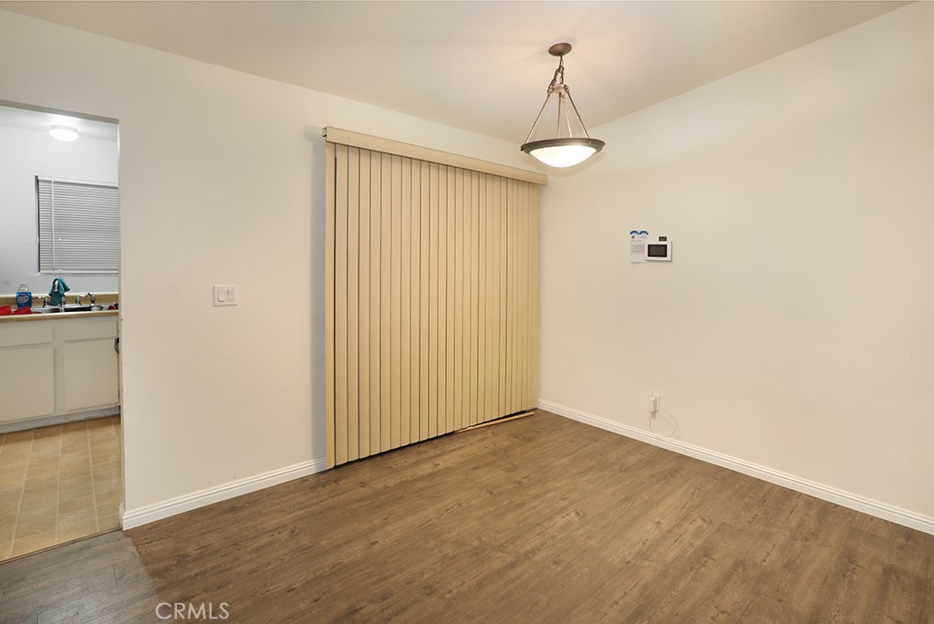 27603 Genevieve Drive Menifee, CA 92586 - Photo 3 of 11 an empty room with wooden floor cabinet and windows