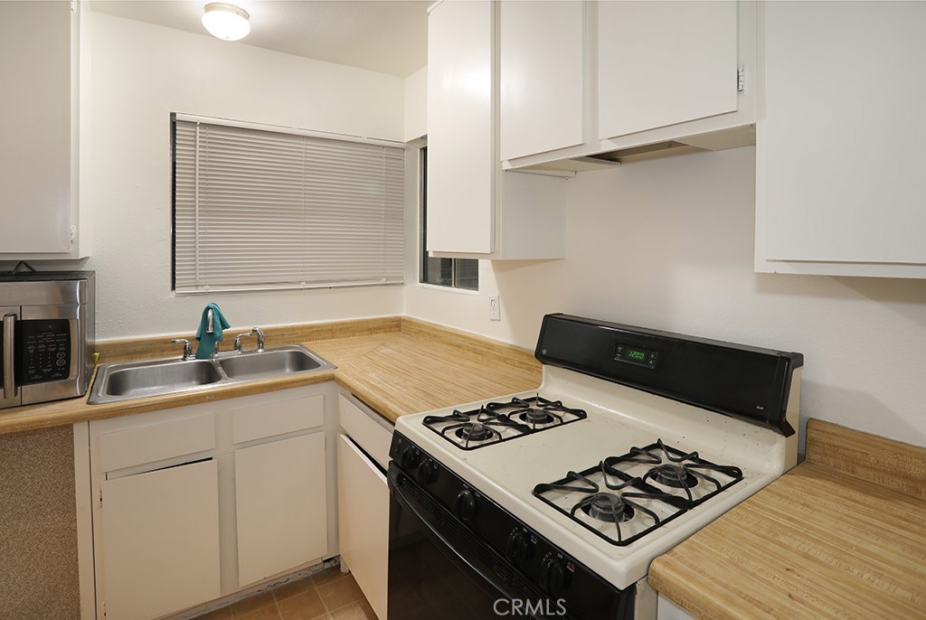 27603 Genevieve Drive Menifee, CA 92586 - Photo 7 of 11 a view of kitchen island with sink stove and cabinets