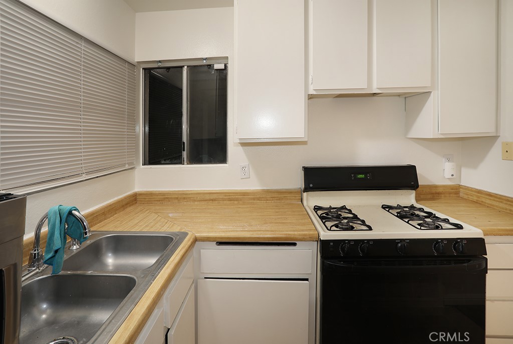 27603 Genevieve Drive Menifee, CA 92586 - Photo 8 of 11 a kitchen with granite countertop a sink a stove and cabinets