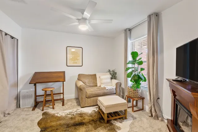 a living room with furniture a flat screen tv and a fireplace